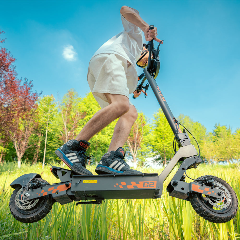 Rider using a KuKirin G2 electric scooter on grass