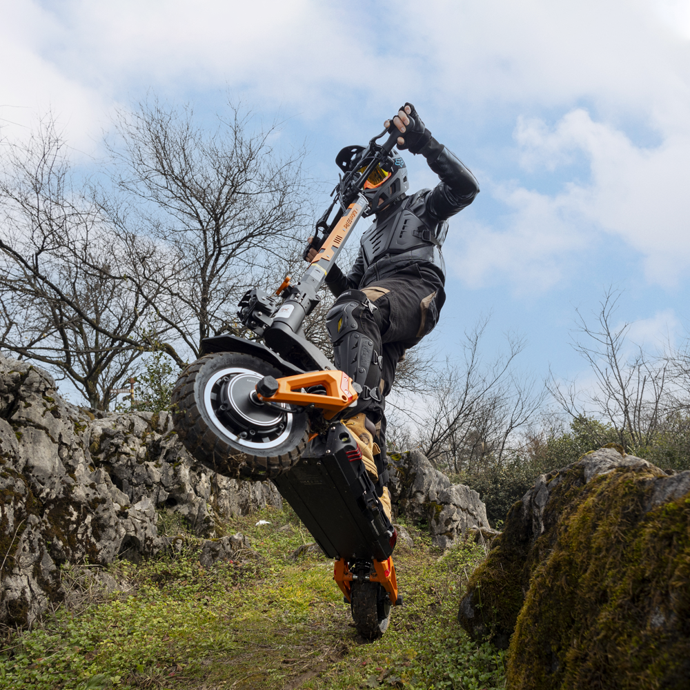 Helmeted rider using a KuKirin G3 Pro electric scooter off road