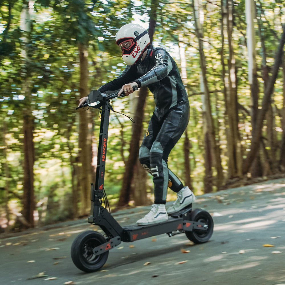 Helmeted rider using a KuKirin G4 electric scooter outdoors