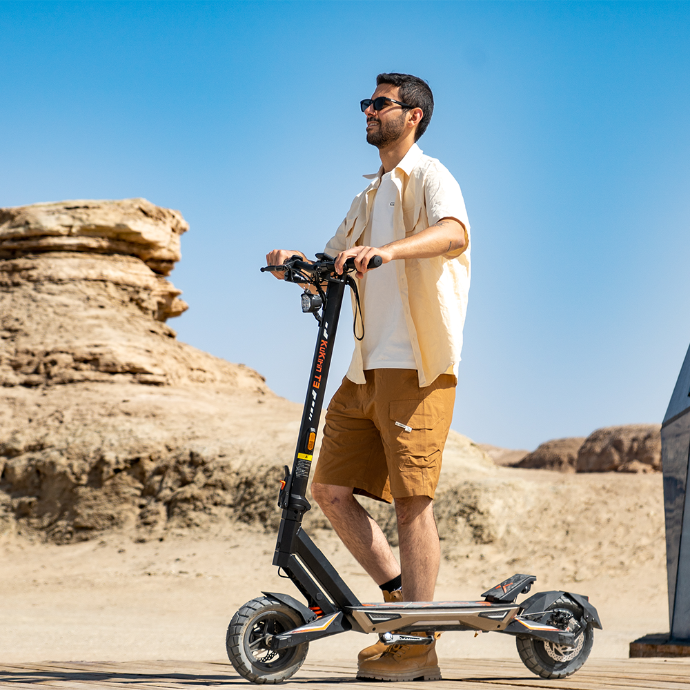 Rider using a KuKirin T3 electric scooter on dry terrain