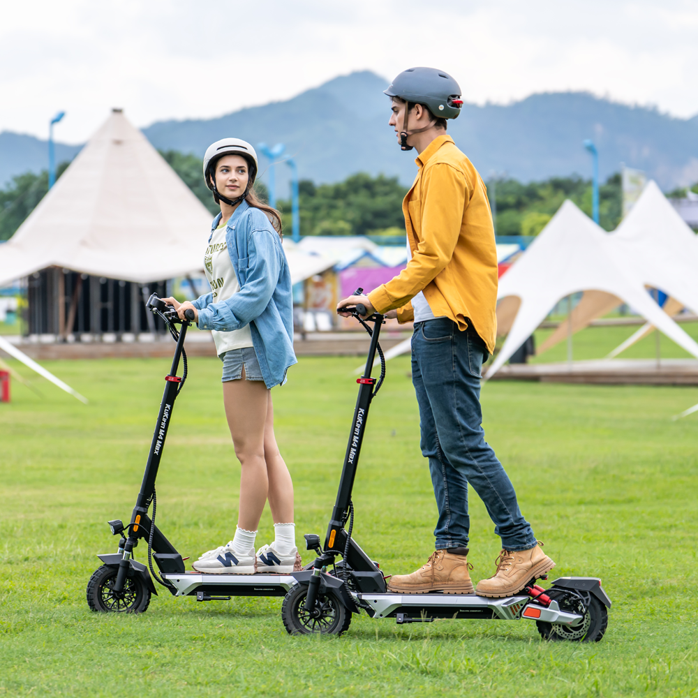 Two helmeted riders with KuKirin M4 Max electric scooters